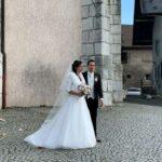 couple de mariés sortant de l'église avec robe de mariée et traine