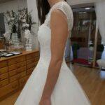 essayage de profil d'une robe de mariée par femme dans la boutique cymbeline à annecy