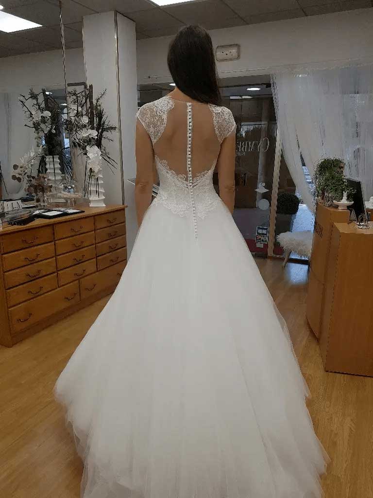 Femme essayant une robe de mariée cymbeline vue de dos dans la boutique d'annecy