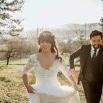 homme et femme en robe de mariée cymbeline annecy courant dans un champ